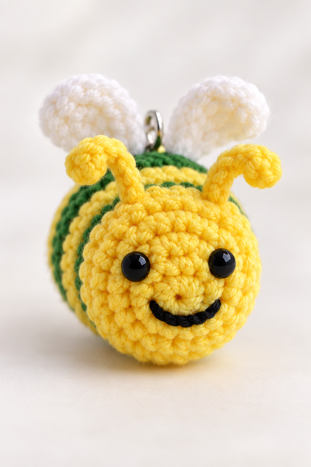 Finished crochet bee keychain with antennae and stitched face