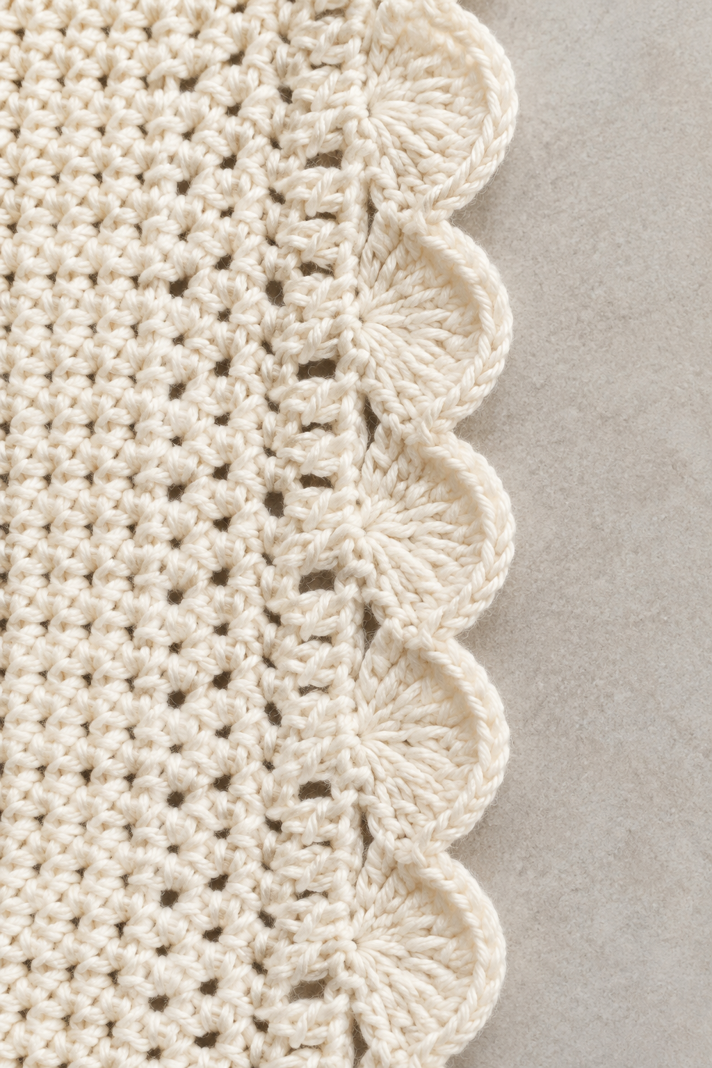 crochet lace trim projects: close view of a scalloped shell crochet border in cream yarn