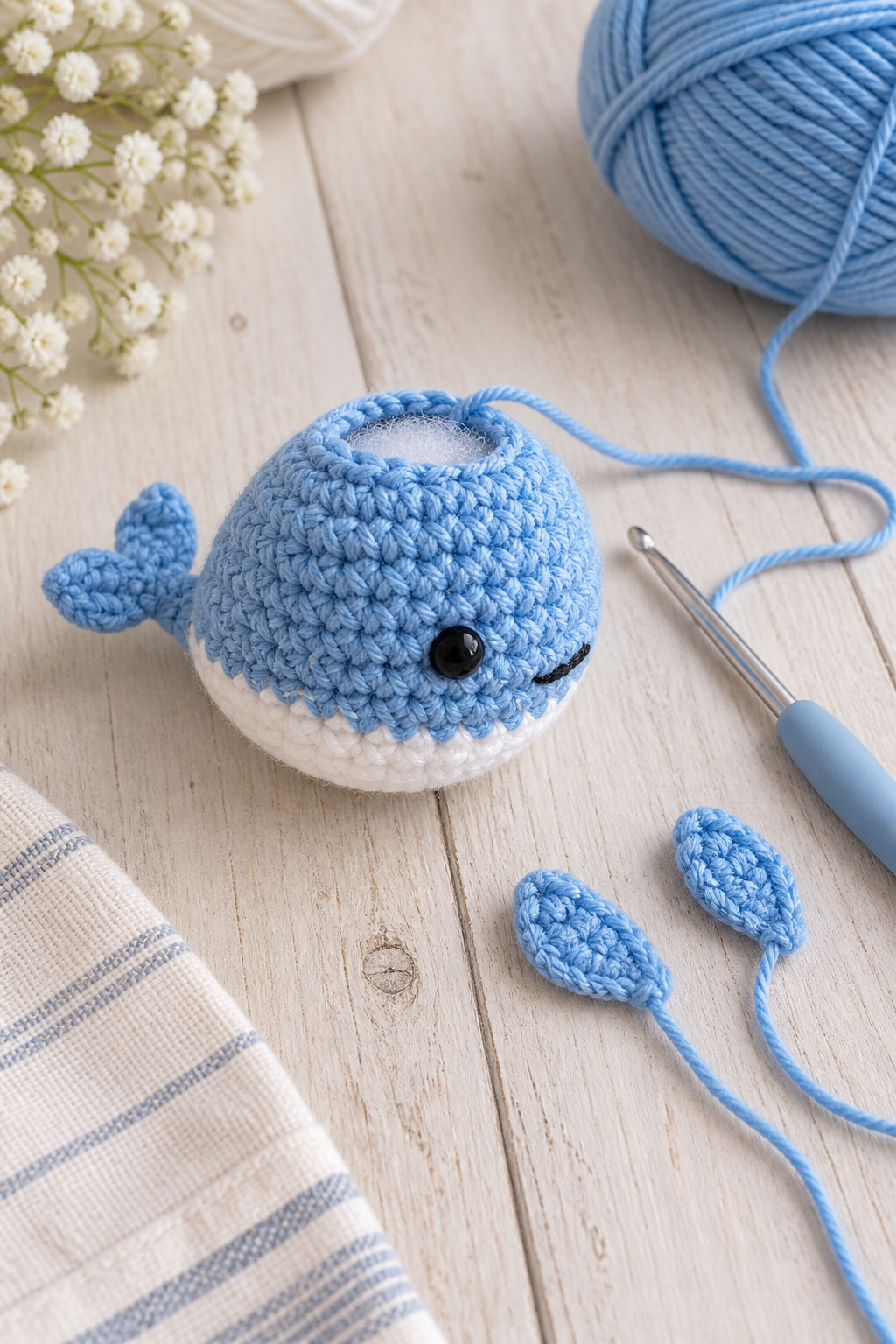 Crochet whale fins being shaped on a craft table