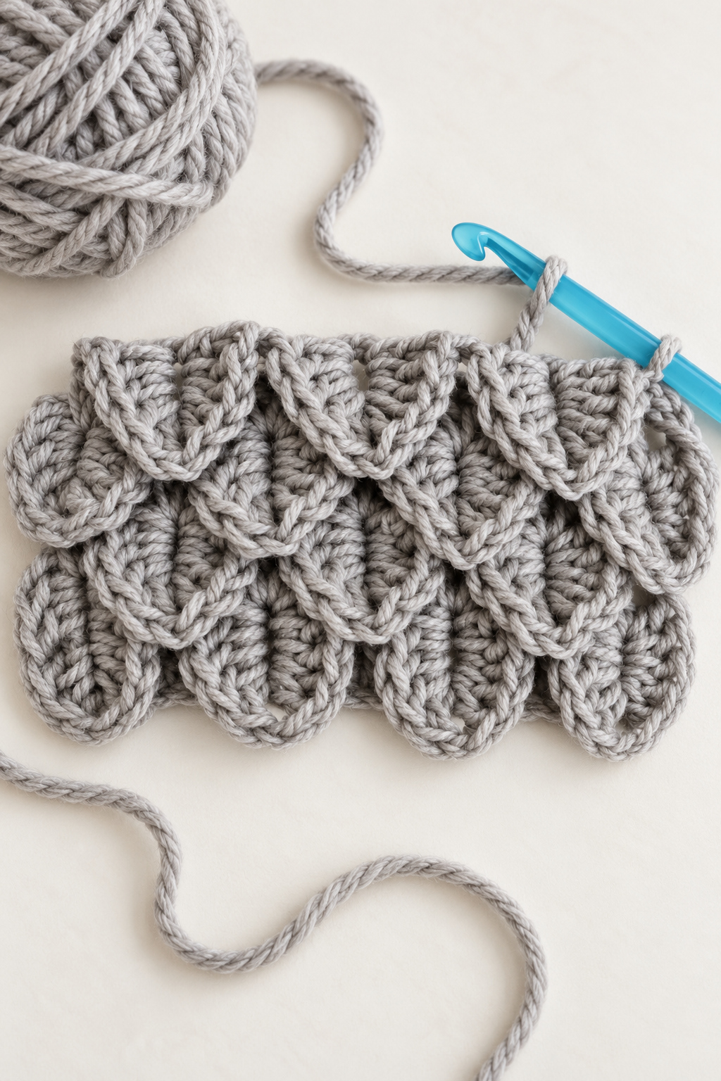 Crochet hook and crocodile stitch swatch arranged for base and scale rows